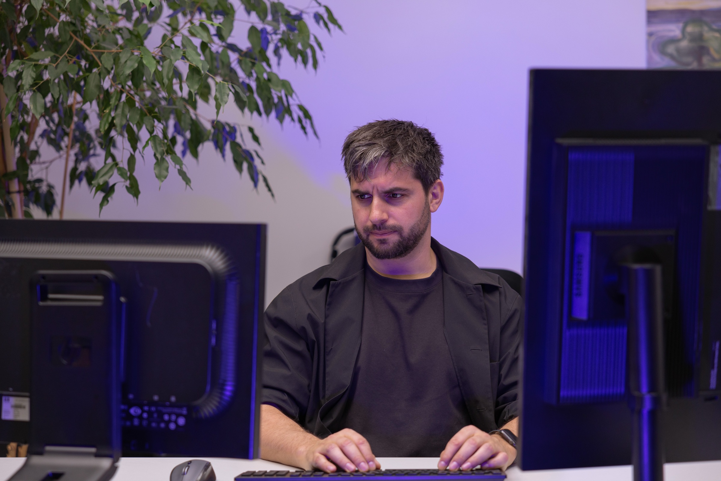 Développeur concentré — double moniteur & plante
