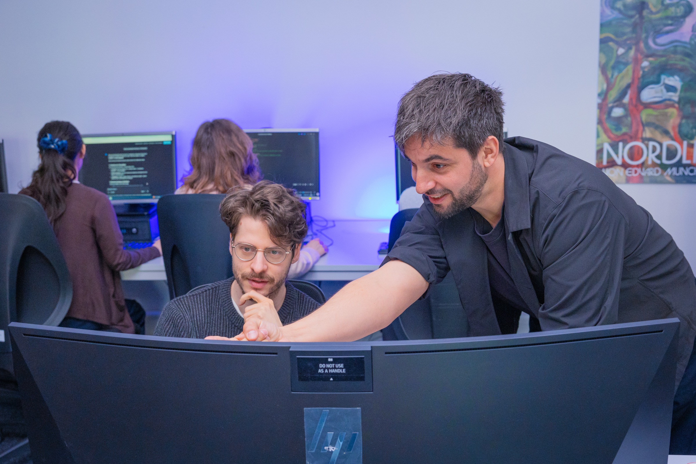 Développeur concentré (poste double moniteur, plante au fond) — prise n°19